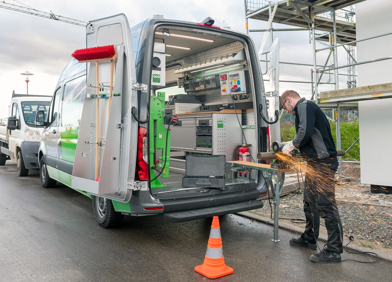 Professional using a mobile workbench fitted to a bott van racking system